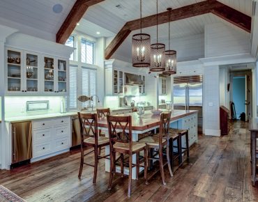 large expensive chefs kitchen in luxury home with rough hewn wood and white cabinets